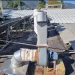 צינורות אוורור עם מפוח צנטריפוגלי ומבנה תומך כחלק ממערכת אוורור תעשייתית