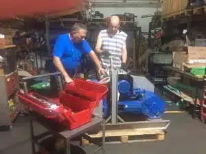 שני טכנאים של חברת סליל המנוע עובדים על תהליך שיפוץ של משאבה תעשייתית